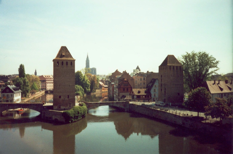Watchtowers stand vigil over canal in Strasbourg while cathedral stands vigil over the town, photograph by C. W. Booth